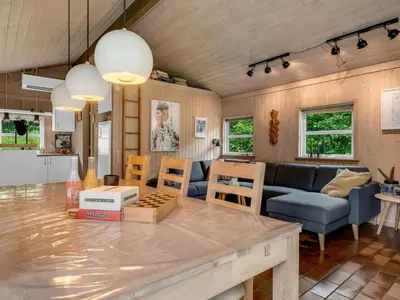 a kitchen and living room with a table and chairs at Holiday Home Ginette - 400m to the fjord by Interhome in Åbybro