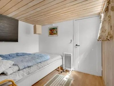 a bedroom with a bed and a sliding door at Holiday Home Goodje - 400m from the sea by Interhome in Blokhus