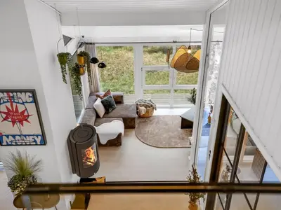 a living room with a couch and a fireplace at Holiday Home Marcus - 500m from the sea by Interhome in Saltum