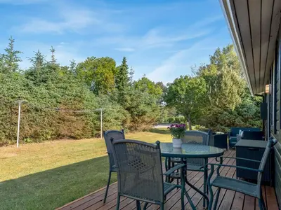 a patio with a table and chairs on a deck at Holiday Home Laris - 700m to the fjord by Interhome in Løgsted