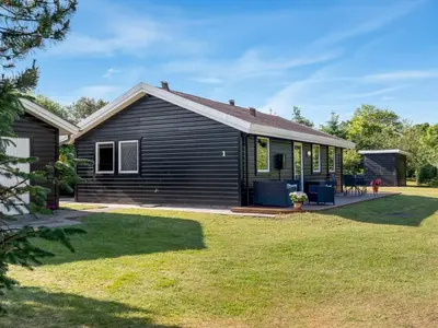 a black house with a yard at Holiday Home Laris - 700m to the fjord by Interhome in Løgsted
