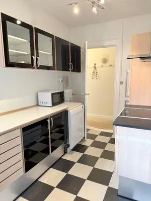 a kitchen with a black and white checkered floor at Cozy pearl downtown Viborg in Viborg