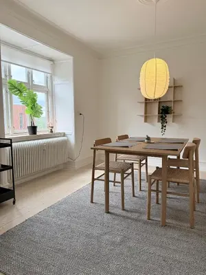 a dining room with a wooden table and chairs at Cozy pearl downtown Viborg in Viborg