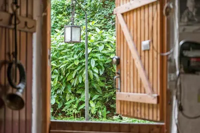 an open door to a garden with a hanging lantern at Villa Bakkely in Lemvig