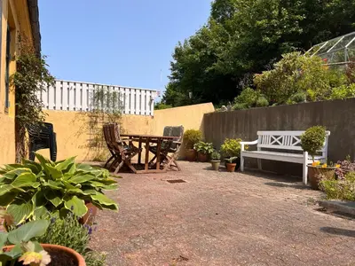 a patio with a picnic table and a bench at Villa Bakkely in Lemvig