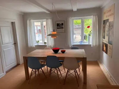 a dining room with a wooden table and chairs at Villa Bakkely in Lemvig