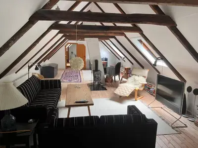 an attic living room with couches and a table at Villa Bakkely in Lemvig