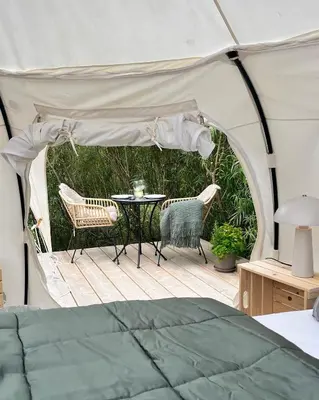 a tent with a table and chairs on a patio at Agger Glamping - Lyngheden in Vestervig