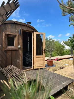 a wooden out house with a door on a deck at Agger Glamping - Lyngheden in Vestervig