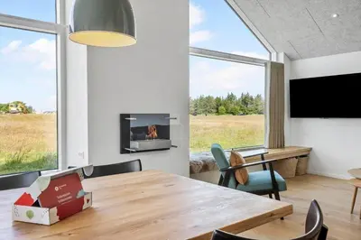 a dining room with a table and a fireplace at 871-Thisted-Smedevej-3-A in Thisted