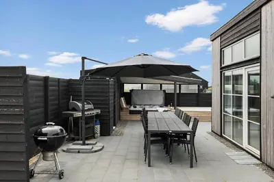 a patio with a table with an umbrella and a grill at 158-Thisted-Lyngbakken-8 in Thisted