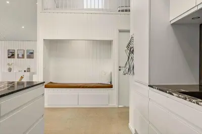 a white kitchen with a bench in the middle at 1314-Thisted-Lyngbakken-14 in Thisted