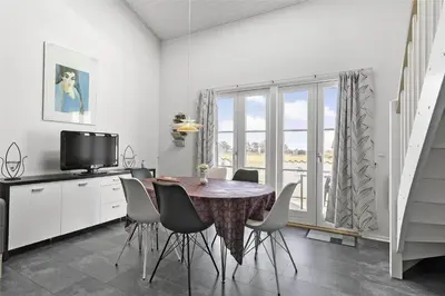 a dining room with a table and chairs and a television at 212-Vestervig-Havnevej-1-lejl-12 in Vestervig