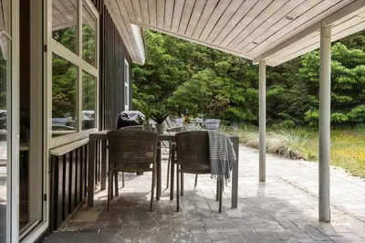 a patio with a table and chairs on a porch at 1067-Thisted-Gra-Rimme-7 in Torsted