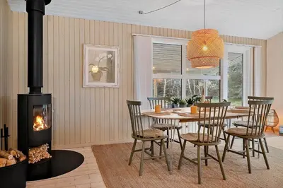 a dining room with a table and a fireplace at 1067-Thisted-Gra-Rimme-7 in Torsted