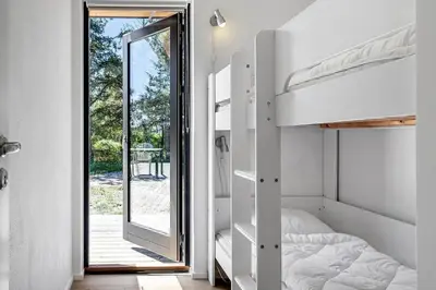a bedroom with bunk beds and a sliding glass door at 1323-Thisted-Fiskervej-96 in Thisted