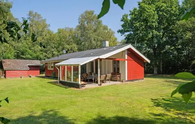 a red house with a patio in a yard at 3 Bedroom Amazing Home In Aabybro in Åbybro