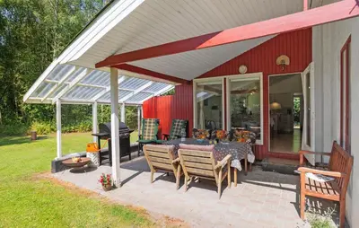 a patio with a table and chairs and a grill at 3 Bedroom Amazing Home In Aabybro in Åbybro