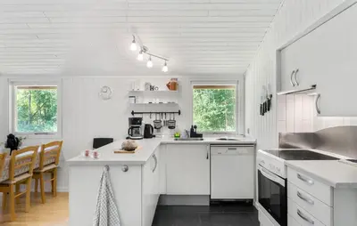 a kitchen with white cabinets and a counter top at 3 Bedroom Amazing Home In Aabybro in Åbybro