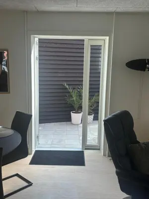 an open door to a patio with a plant at Ny lækker lejlighed på Havnen in Thyborøn