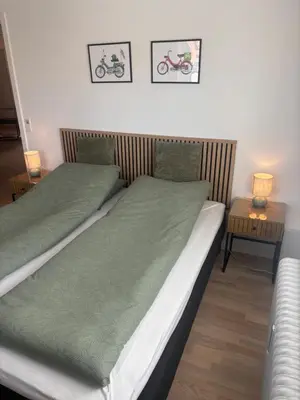 two beds in a room with two tables and two lamps at Ny lækker lejlighed på Havnen in Thyborøn