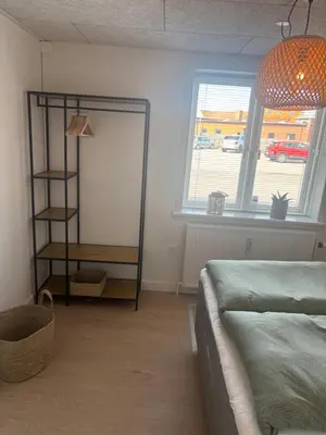 a living room with a couch and a mirror at Ny lækker lejlighed på Havnen in Thyborøn