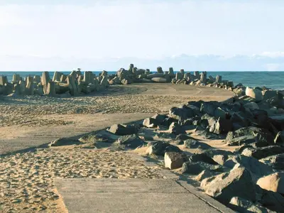 a beach with a bunch of rocks and the ocean at 4 star holiday home in Thyborøn in Thyborøn