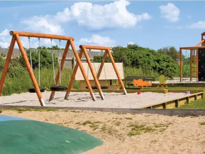 a playground with two swings in a park at 4 star holiday home in Thyborøn in Thyborøn