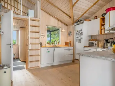 a kitchen with white appliances and a wooden ceiling at Holiday Home Diderik - 20m to the fjord by Interhome in Roslev