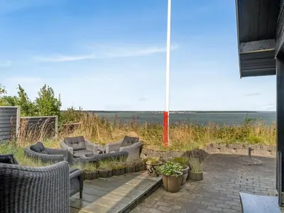 a patio with furniture and a view of the ocean at Holiday Home Diderik - 20m to the fjord by Interhome in Roslev