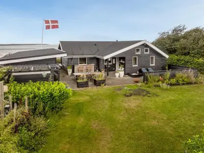 a house with a flag on top of a yard at Holiday Home Diderik - 20m to the fjord by Interhome in Roslev
