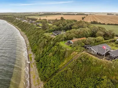 an aerial view of a house on a hill next to the water at Holiday Home Diderik - 20m to the fjord by Interhome in Roslev