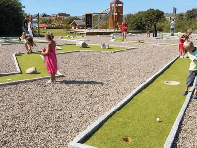 a group of children playing with a dog in a playground at 4 star holiday home in Thyborøn in Thyborøn
