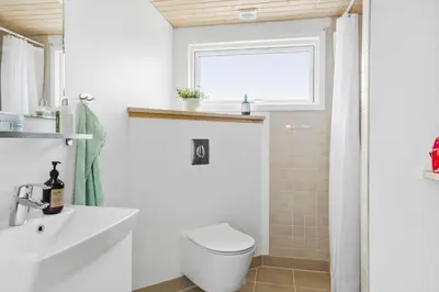 a bathroom with a toilet and a sink and a window at 399-Thisted-Sotungevej-21 in Nørre Vorupør