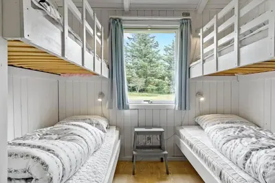 two beds in a small room with a window at 421-Thisted-Fiskervej-147 in Nørre Vorupør