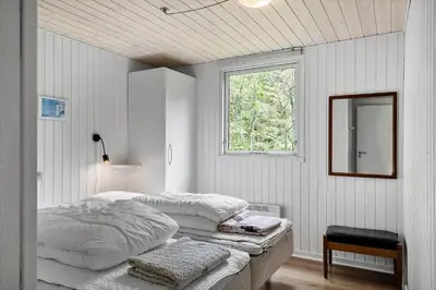 two beds in a white room with a window at 724-Vestervig-Kanalvej-24 in Tåbel