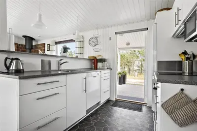 a kitchen with white cabinets and black counter tops at 880-Thisted-Havtornvej-4 in Thisted