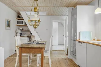 a kitchen with a wooden table and white cabinets at 872-Bedsted-Thy-Lyngbyvej-25 in Bedsted Thy
