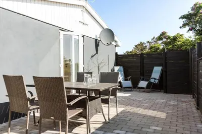 a patio with a wooden table and chairs at 1046-Thisted-Johns-Vej-26 in Torsted