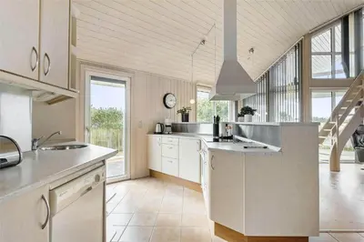 a large kitchen with white cabinets and a large window at 644-Thisted-Kristinesvej-4 in Thisted