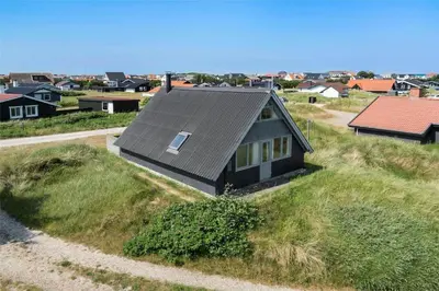 a small house on top of a grassy hill at 465-Thisted-Havbovej-25 in Thisted