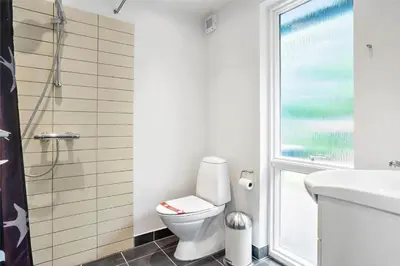 a bathroom with a toilet and a sink and a window at 454-Thisted-Havbovej-36 in Thisted