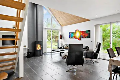 a living room with a fireplace and a table and chairs at 454-Thisted-Havbovej-36 in Thisted
