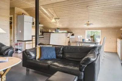 a living room with a leather couch and a kitchen at 528-Thisted-Tunvej-28 in Thisted