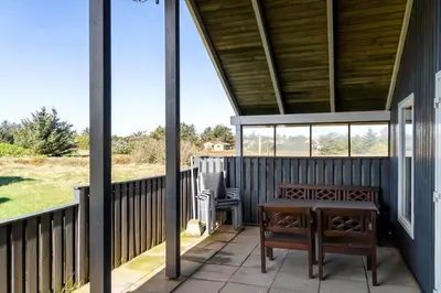 a porch with two benches and a table on it at 323-Thisted-Pighvarvej-27 in Thisted