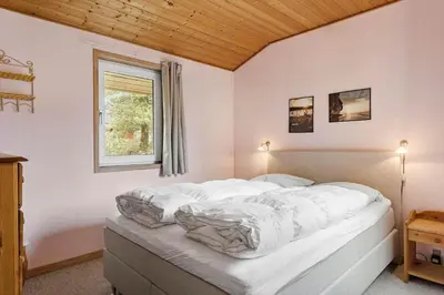 a bedroom with a bed with white sheets and a window at 560-Thisted-Klitrosevej-60 in Thisted