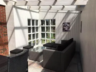 a patio with chairs and a table and windows at 707-Thisted-Lyngvej-12 in Thisted