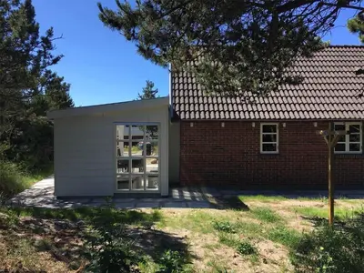 a small shed with a door next to a brick building at 707-Thisted-Lyngvej-12 in Thisted