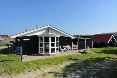 a small black house with a table in the yard at 1303-Thisted-Fiskervej-47 in Thisted