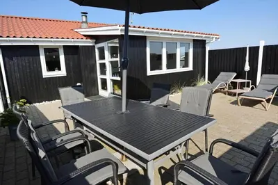 a table and chairs with an umbrella on a patio at 1303-Thisted-Fiskervej-47 in Thisted